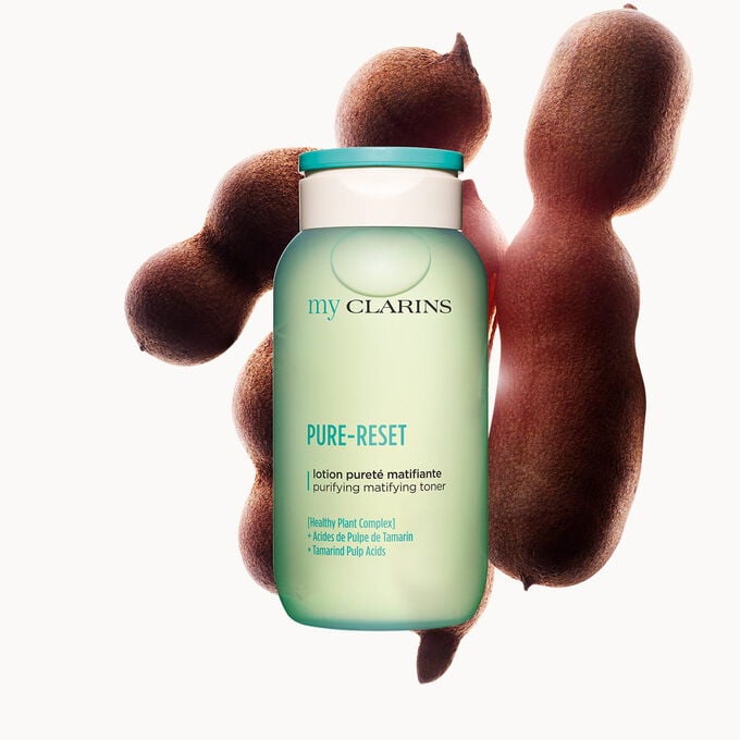Packshot of a purifying and matifying facial lotion alongside tamarind beans on a light blue background