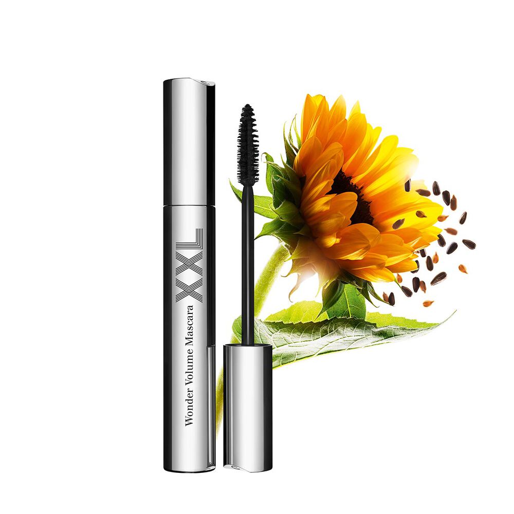 Packshot of an open lengthening black mascara by Clarins, displayed in front of a sunflower on a white background