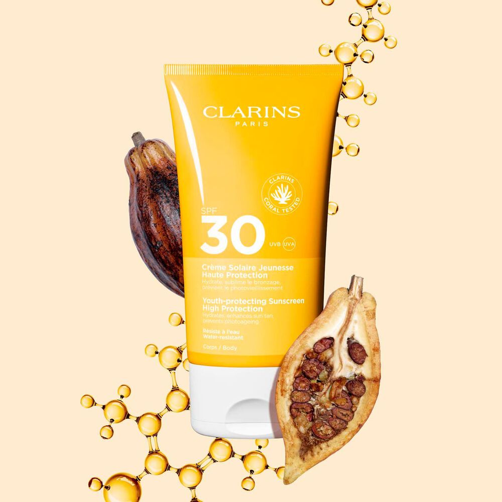Photo of Clarins Youth-Protecting Sunscreen High Protection SPF 30 for the body, among collagen molecules and cocoa beans.