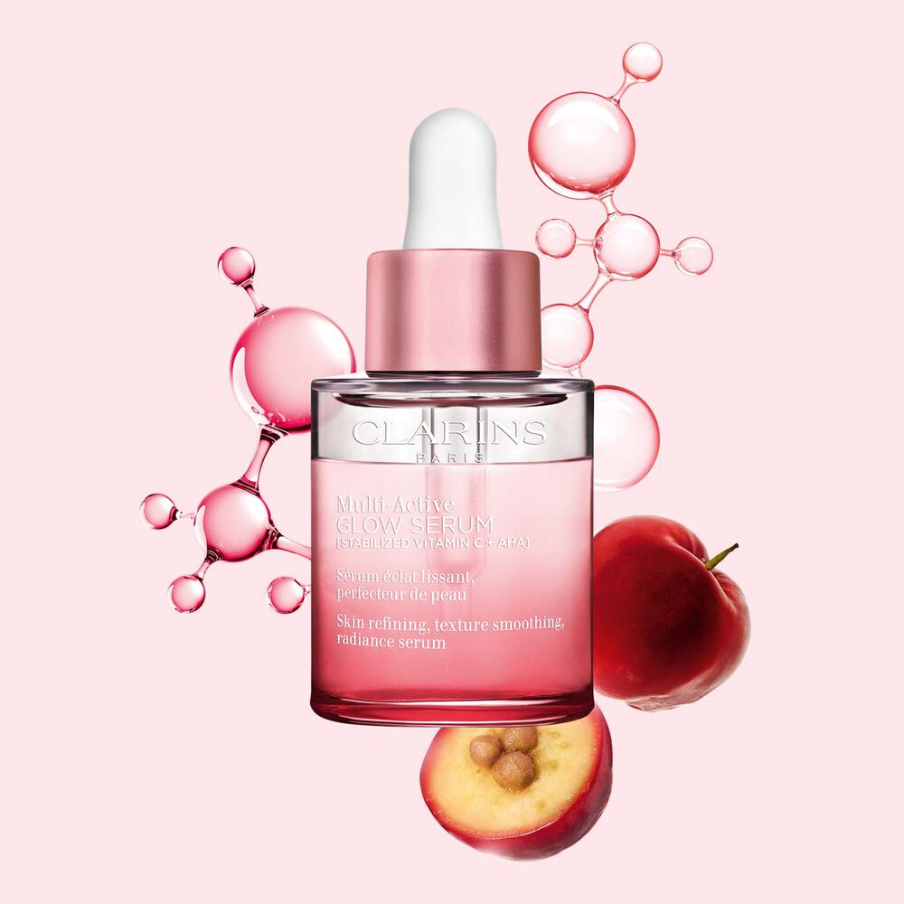 Pack shot of Multi-Active Glow Serum with vitamin C molecule and acerola on a light pink background, enhancing skin radiance.