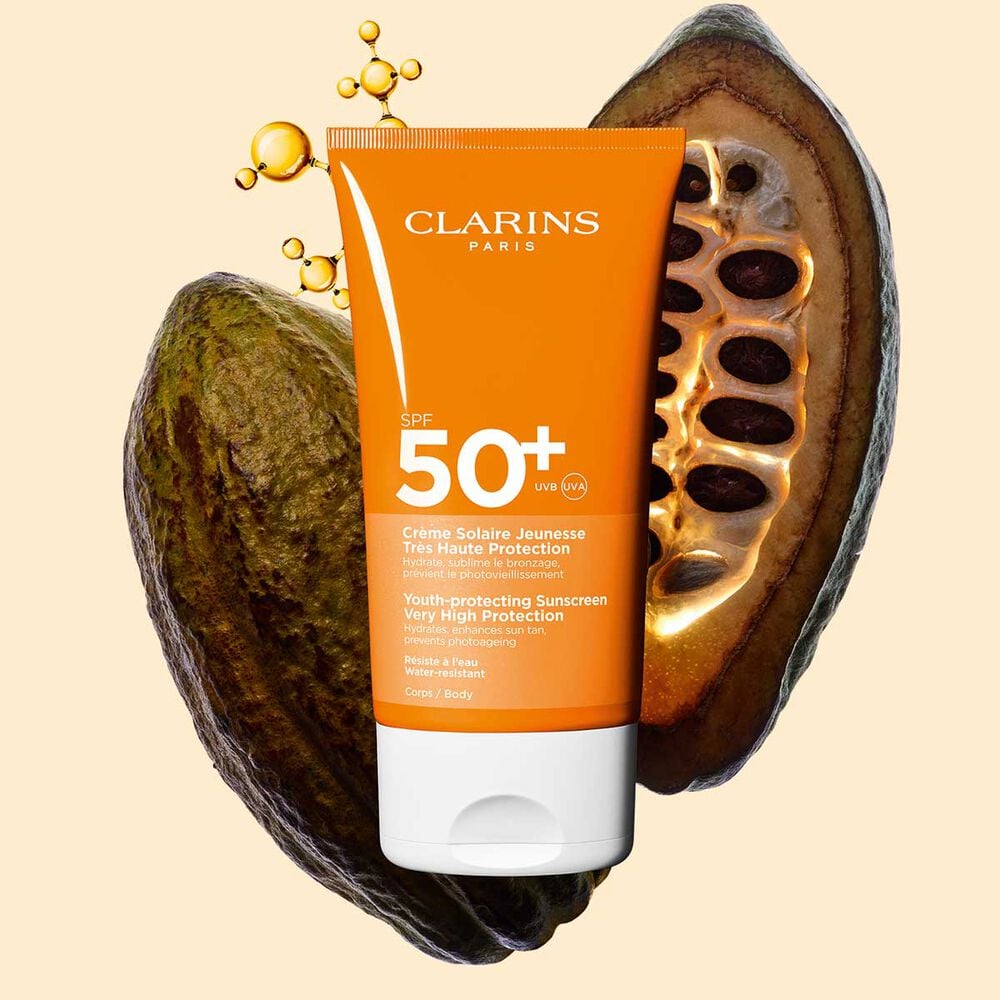 Photo of Clarins Youth-Protecting Sunscreen High Protection SPF 50 for the body, among collagen molecules and cocoa beans.