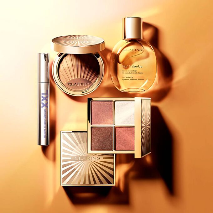 Packshot of Clarins summer makeup essentials, featuring an All-in-One Palette, Bronzing Powder, Makeup Fixer Spray, and Mascara