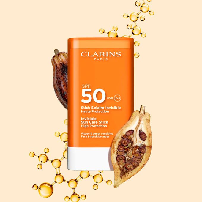 Packshot of Clarins Invisible Sun Care Stick High Protection SPF 50 for the face among collagen molecules and cocoa beans.