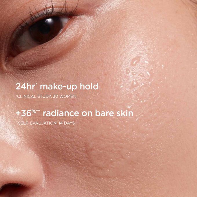 Focus on a woman's cheek with a mist trace, illustrating the 24-hour makeup hold and radiant effect on the skin.