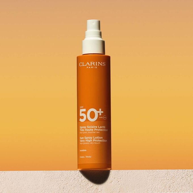 Packshot of a sun body lotion factor 50 spray with a message announcing that Clarins is committed to environmental protection