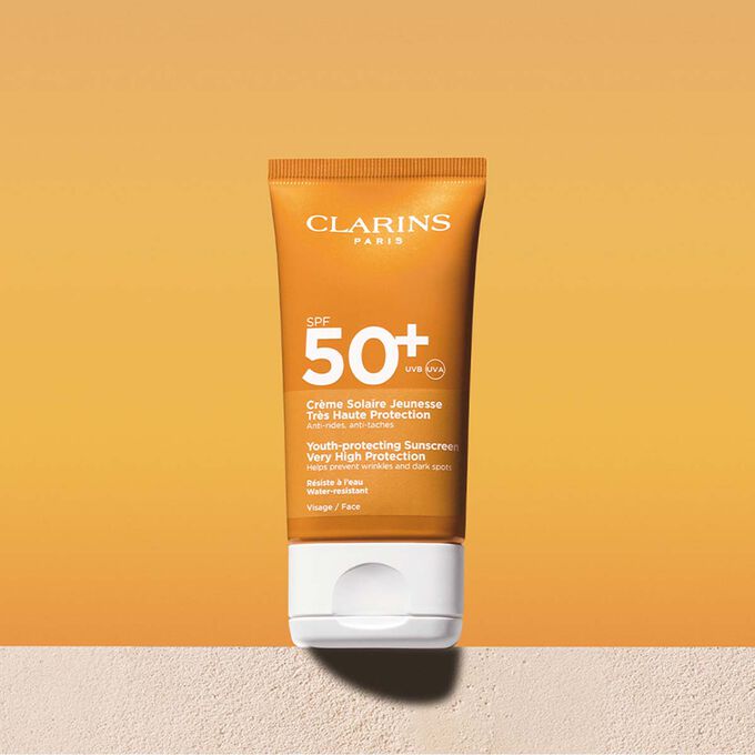 Packshot of a facial sun cream factor 50 tube with a message announcing that Clarins is committed to environmental protection