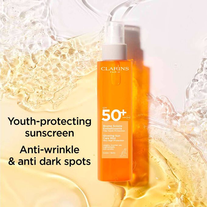 A bottle of Clarins Glowing Sun Care Mist, highlighting its youth-protecting benefits: anti-wrinkle, and dark spot defense.