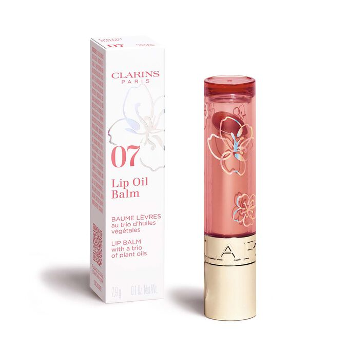 Photoshoot of a tube of Clarins Fairy Blossoms Lip Oil Balm in the shade Petal Nude with its elegant secondary packaging.