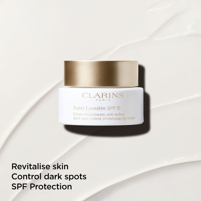 Anti-dark spot day cream with SPF 15 on a textured background, emphasizing its skin revitalizing action
