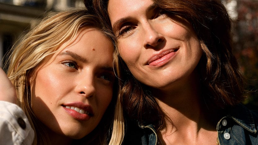 A mature woman, a mother, with her daughter in her twenties; both radiant
