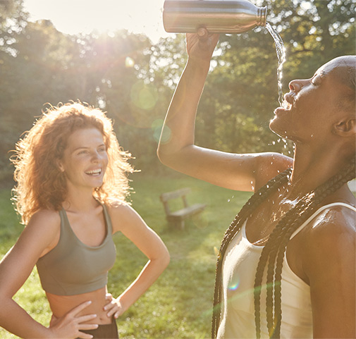 2 yound women drinking water and laughing